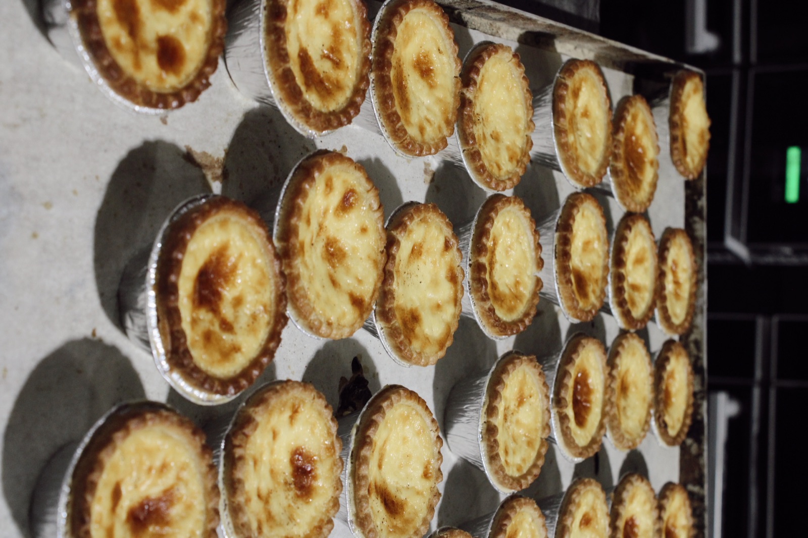 Freshly baked custard tarts coming out of the oven at Knotts Bakery
